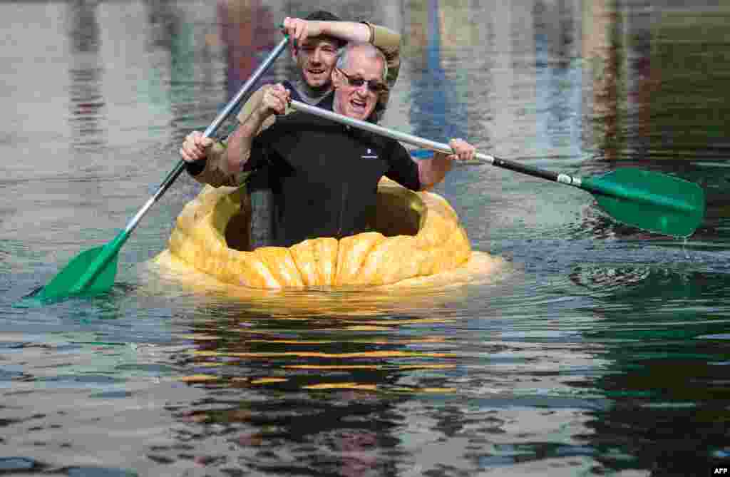 Participants paddle in hollowed out giant pumpkins during the traditional pumpkin paddling in Fambach near Schmalkalden, central Germany.