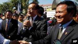 Opposition leader of Cambodia National Rescue Party Sam Rainsy, center, delivers a speech next to his Deputy President Kem Sokha, right, during a gathering to mark Human Rights Day, in front of National Assembly, in Phnom Penh, Cambodia, file photo. 