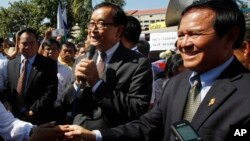 Opposition leader of Cambodia National Rescue Party Sam Rainsy, center, delivers a speech next to his Deputy President Kem Sokha, right, during a gathering to mark Human Rights Day, in front of National Assembly, file photo. 