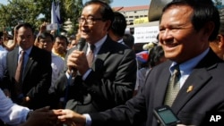 Opposition leader of Cambodia National Rescue Party Sam Rainsy, center, delivers a speech next to his Deputy President Kem Sokha, right, during a gathering to mark Human Rights Day, in front of National Assembly, in Phnom Penh, Cambodia, file photo. 