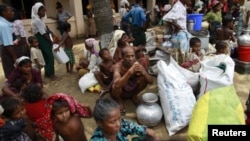 FILE - People from a Rohingya internally displaced persons (IDP) camp wait for a vehicle to return to their camp after waiting out cyclone Mahasen in a mosque outside Sittwe.