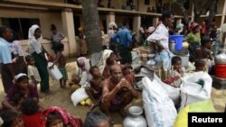 Rohingya internally displaced persons wait for aid after a cyclone in a camp in Myanmar.