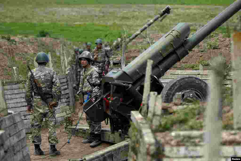 Ethnic Armenian soldiers stand next to a cannon at artillery positions near the Nagorno-Karabakh&#39;s town of Martuni.