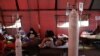Seorang pasien COVID-19 terbaring di atas velbed di tenda sementara di luar ruang gawat darurat rumah sakit pemerintah di Bekasi, 25 Juni 2021. Awal pekan ini pasokan oksigen medis di Jawa Tengah dan Yogyakarta sempat terganggu. (Foto: REUTERS/Willy Kurniawan)