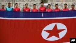 지난 18일 인천 아시안게임 남자축구 F조 1차전 파키스탄과의 경기에 출전한 북한 선수단이 인공기 앞에 서 있다.