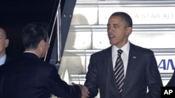 President Barack Obama is welcomed by Japanese Foreign Minister Seiji Maehara, left, upon arrival at Haneda international airport in Tokyo Friday, Nov. 12, 2010. Obama is visiting Japan to attend meetings of the APEC forum held in Yokohama this weekend. (