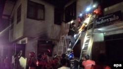 Thai firefighters and rescue workers remove an injured Thai student (top) after a fire broke out at a school dormitory in Chiang Rai province, northern Thailand, early 23 May 2016. At least 17 elementary girl students died and five were injured.