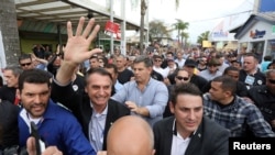 FILE PHOTO: Presidential candidate Jair Bolsonaro is greeted by supporters during an agribusiness fair in Esteio, Rio Grande do Sul state, Brazil Aug. 29, 2018. 