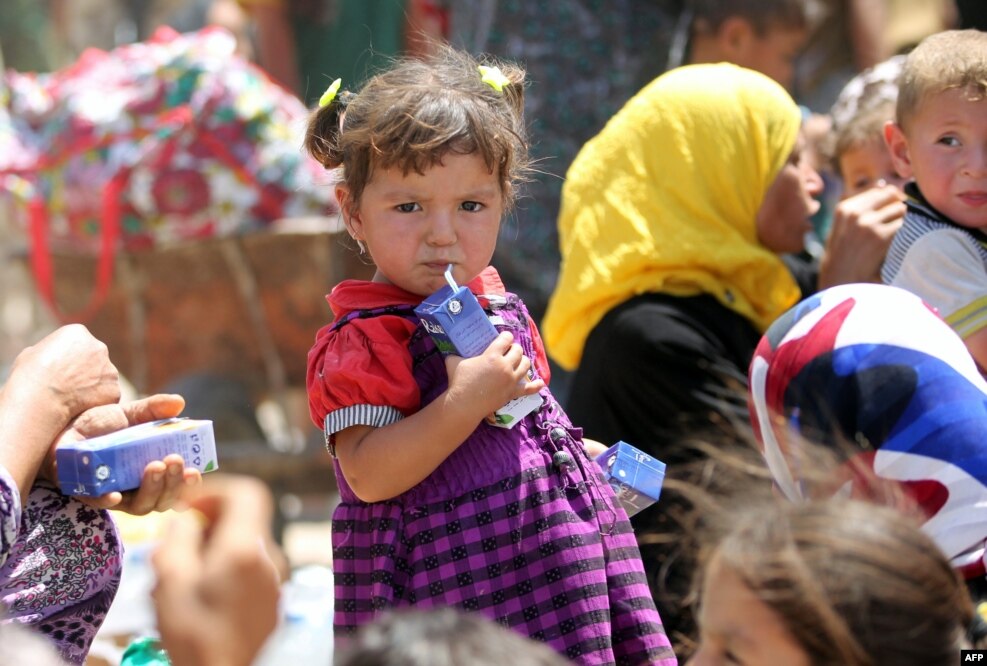 An Iraqi girl drinks juice near al-Sejar village, in Iraq's Anbar province, after fleeing with her family the city of Fallujah during a major operation by Pro-government forces to retake the city of Fallujah, from the Islamic State (IS).