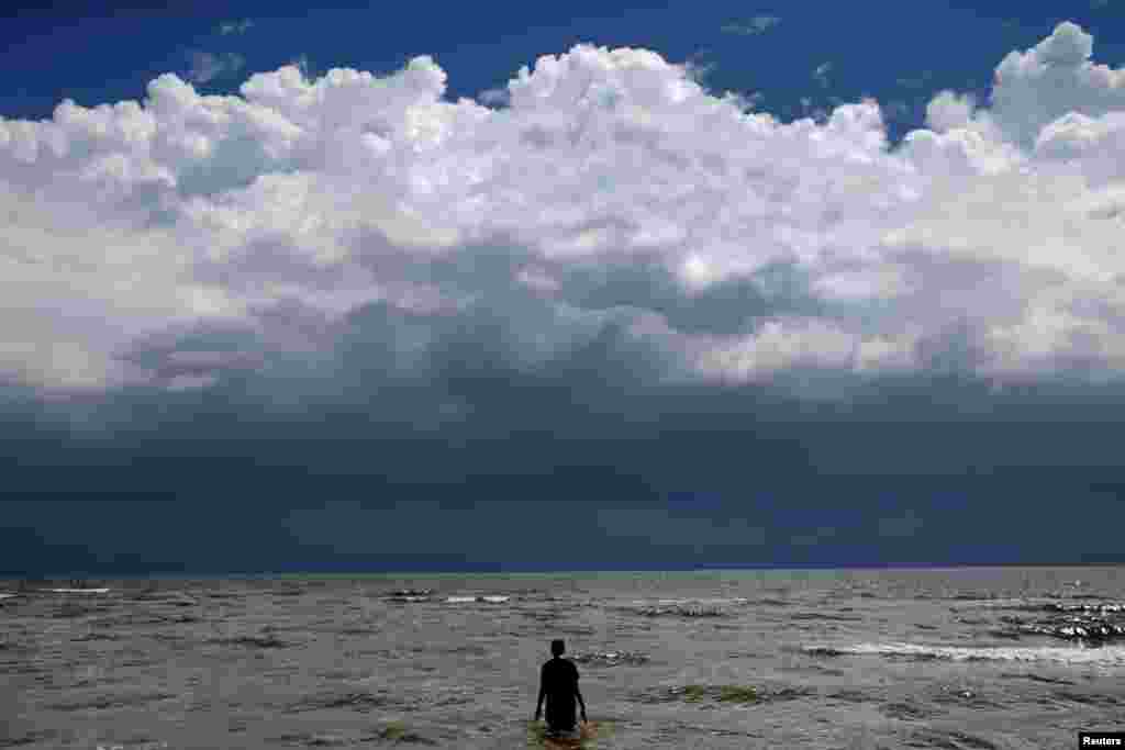 15-year-old Jordan Carambat wades in the ocean as Tropical Storm Gordon approaches Waveland, Mississippi, Sept. 4, 2018.