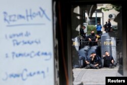 Mobile brigade (Brimob) police officers take a rest near a damaged police station after riots following the announcement of last month's presidential election results outside the Election Supervisory Agency (Bawaslu) headquarters in Jakarta, Indonesia, May 23, 2019.