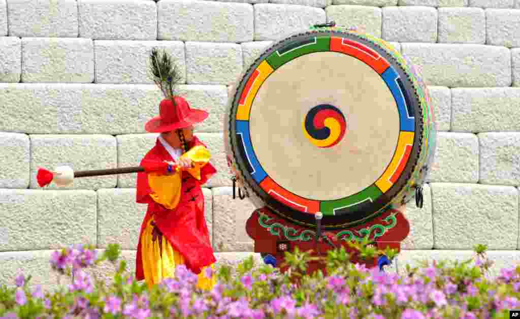 A South Korean traditional gate guard beats a drum during the reopening ceremony of landmark Sungnyemun gate in Seoul. Five years after an arsonist destroyed it, the stone-and-wood southern gate to the old walled capital of Seoul has been painstakingly restored to its late 14th century glory by a small army of master craftsmen using traditional tools.