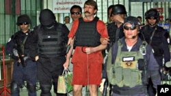 With tight security and the flak jacket on, Viktor Bout, center, a suspected Russian arms dealer, leaves the criminal court in Bangkok, Thailand, 04 Oct. 2010