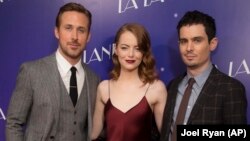 Director Damien Chazelle, right, alongside actors Ryan Gosling and Emma Stone pose for photographers upon arrival at the screening of the film 'La La Land' in London, Thursday, Jan. 12, 2017.