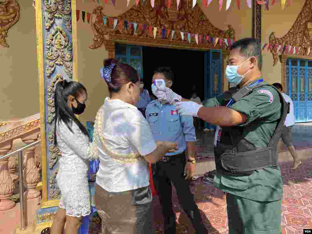 វត្តអារាម​មួយ​ នៅ​រាជធានីភ្នំពេញ​ មាន​ការ​វាស់​កំដៅ​ និង​បាញ់​ទឹក​អាល់កុល​លាងដៃ​ មុន​ពេល​អនុញ្ញាតិ​ឲ្យ​ពុទ្ធ​បរិស័ទ​ចូល​ក្នុង​វត្ត​ រាជធានី​ភ្នំពេញ នៅថ្ងៃ​ទី​ ១៤ ខែ​មេសា​ ឆ្នាំ២០២០។ (ហ៊ាន​ សុជាតា​/VOA)