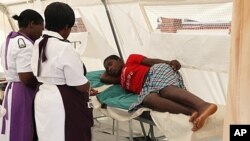 FILE: Harare nurses inspecting a typhoid patient.