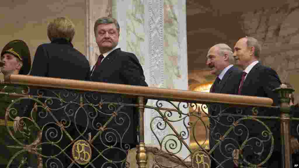 German Chancellor Angela Merkel, left back to a camera, Ukrainian President Petro Poroshenko, second left, Belarusian President Alexander Lukashenko, second right, and Russian President Vladimir Putin, walk together to continue their peace talks in Minsk,