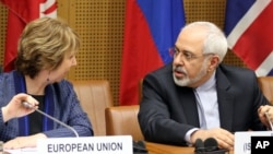 European Union's Catherine Ashton, left, and Iran's Mohammad Javad Zarif await start of closed-door nuclear talks, Vienna, June 17, 2014.