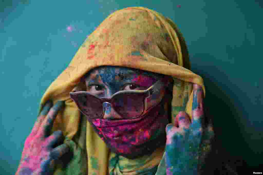 A woman poses for a photograph during Holi celebrations in the town of Barsana in the state of Uttar Pradesh, India.