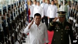 Philippine President Rodrigo Duterte, left, salutes during departure honors at Manila's International Airport, Philippines on Wednesday, Nov. 9, 2016. 