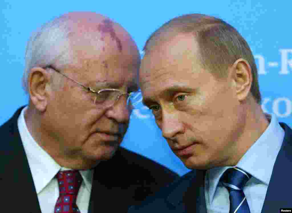 Russian President Putin listens to former President of the Soviet Union Gorbachev during news conference in Schleswig, Germany, December 21, 2004. 