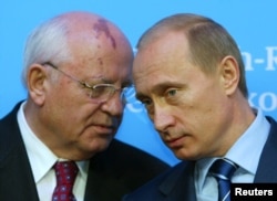 Russian President Vladimir Putin listens to former President of the Soviet Union Mikhail Gorbachev during news conference in Schleswig, Germany, December 21, 2004.