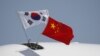 FILE - Flags from South Korea, left, and China flutter atop an aircraft at Beijing Capital International Airport in China, Sept. 2, 2015.