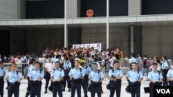警方準備在公民廣場清場前堅守的學生和市民高呼口號（美國之音圖片/海彥拍攝）