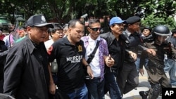 Thai Red Shirt anti-government protest leaders Nattawut Saikuar (2L) and Wiphuthalang (3R, blue cap) are arrested by police officers after they announced to the crowd their surrender on the stage inside the protesters' camp in downtown Bangkok, 19 May 201