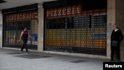 A man walks past closed restaurant during a blackout in Caracas, Venezuela, March 26, 2019. 
