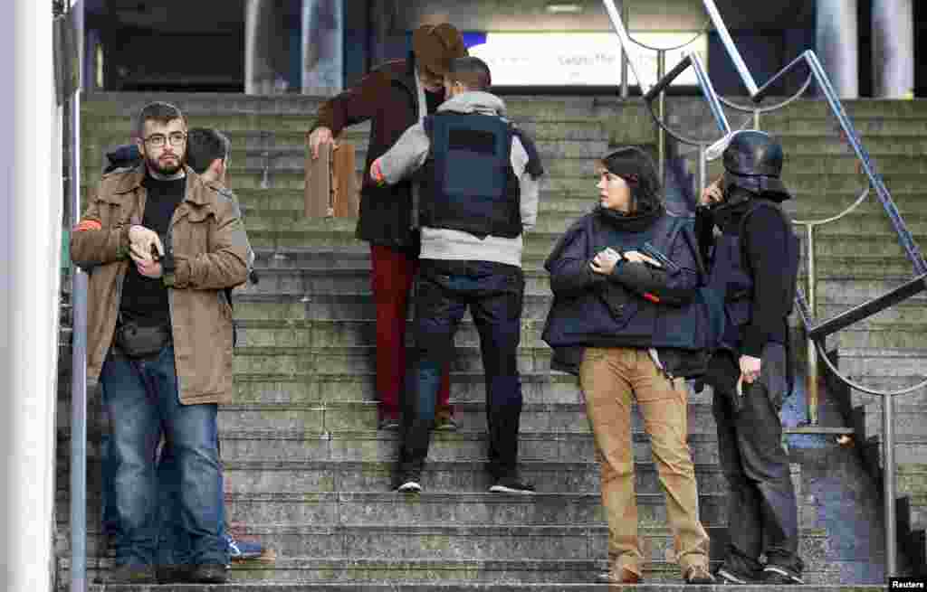 French police check a pedestrian as they secure the area after a man was shot dead at a police station in the 18th district in Paris. Police shot dead a knife-wielding man who tried to enter a police station, police union sources said. The incident took place on the anniversary of last year&#39;s deadly Islamist militant attacks on the Charlie Hebdo satirical magazine in the French capital.