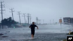 Un sujeto cruza la carretera mientras el huracán Arthur golpea a Carolina del Norte este 4 de julio.