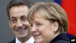 French President Nicolas Sarkozy, left, smiles as he greets German Chancellor Angela Merkel prior to their meeting at the Elysee Palace in Paris, December 5, 2011.