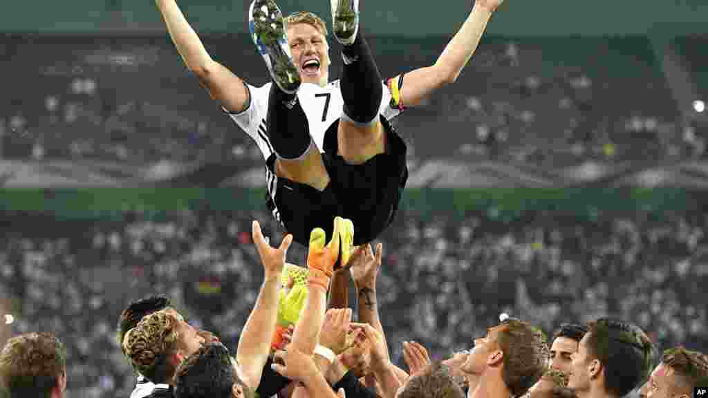 L'équipe nationale de football de l'Allemagne lance son capitaine Bastian Schweinsteiger dans l'air après avoir joué son dernier match pour l'équipe nationale à Moenchengladbach, en Allemagne, le 31 août 2016.