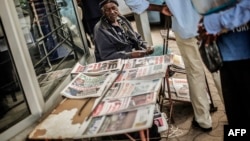 A Street vendor sells newpapers with elections headlines at a central street, Oct. 16, 2014 in Maputo. 