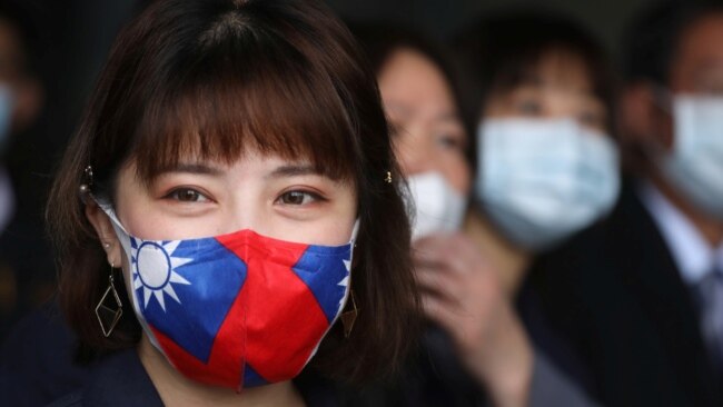 台湾桃园一家制造用于防疫口罩的医用无纺布工厂的职工戴着印有台湾旗帜的口罩。(2020年3月30日)