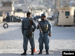 Afghan policemen keep watch at the site of an attack after an overnight battle outside a base in Kabul, Afghanistan, Aug. 8, 2015.