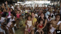 Filipino women and their children participate in a family planning fair to commemorate World Population Day in Manila, Philippines, July 11, 2012.