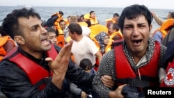 A Greek Red Cross volunteer comforts a crying Syrian refugee moments after disembarking from a flooded raft at a beach on the Greek island of Lesbos, Oct. 20, 2015.