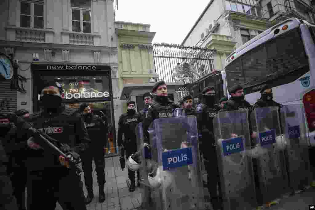 Polisi anti-huru-hara berdiri di luar konsulat Belanda sementara pendukung Presiden Turki Recep Tayyip Erdogan melakukan demonstrasi di Istanbul (11/3). (AP/Emrah Gurel)