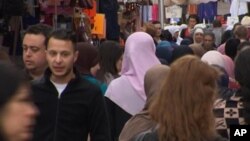 Salah Abdeslam, 2e à gauche, visible sur une image prise d’une vidéo en plein marché de Molenbeek, Bruxelles, Belgique, août 2014
