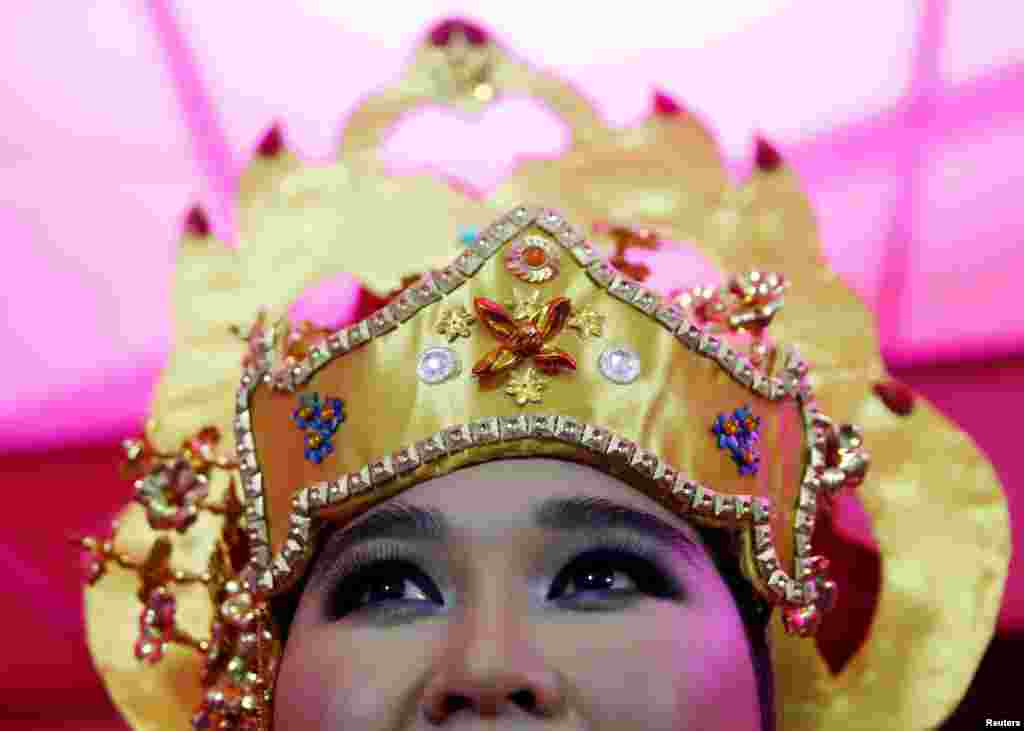 A dancer waits backstage at a street festival to celebrate Brunei's upcoming royal wedding in Bandar Seri Begawan. The royal wedding ceremony of Prince Abdul Malik and his bride Dayangku Rabiatul Adawiyah Pengiran Haji Bolkiah will be held at the Nurul Iman Palace in Brunei's capital on Sunday.