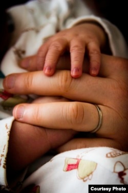 A mother holding a child's hand