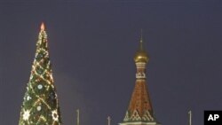 People walk in Red Square decorated for New Year and Christmas celebrations, with St. Basil Cathedral in the background, in Moscow, Russia, Friday, Dec. 30, 2011. (AP Photo/Mikhail Metzel)