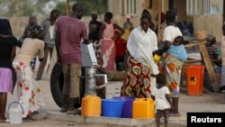 FILE - People gather at a tap in the Malkohi camp for internally displaced people as they collect water in Yola, Nigeria.