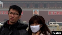 A woman wears a mask as she visits Tiananmen Square in Beijing, Jan. 13, 2013.