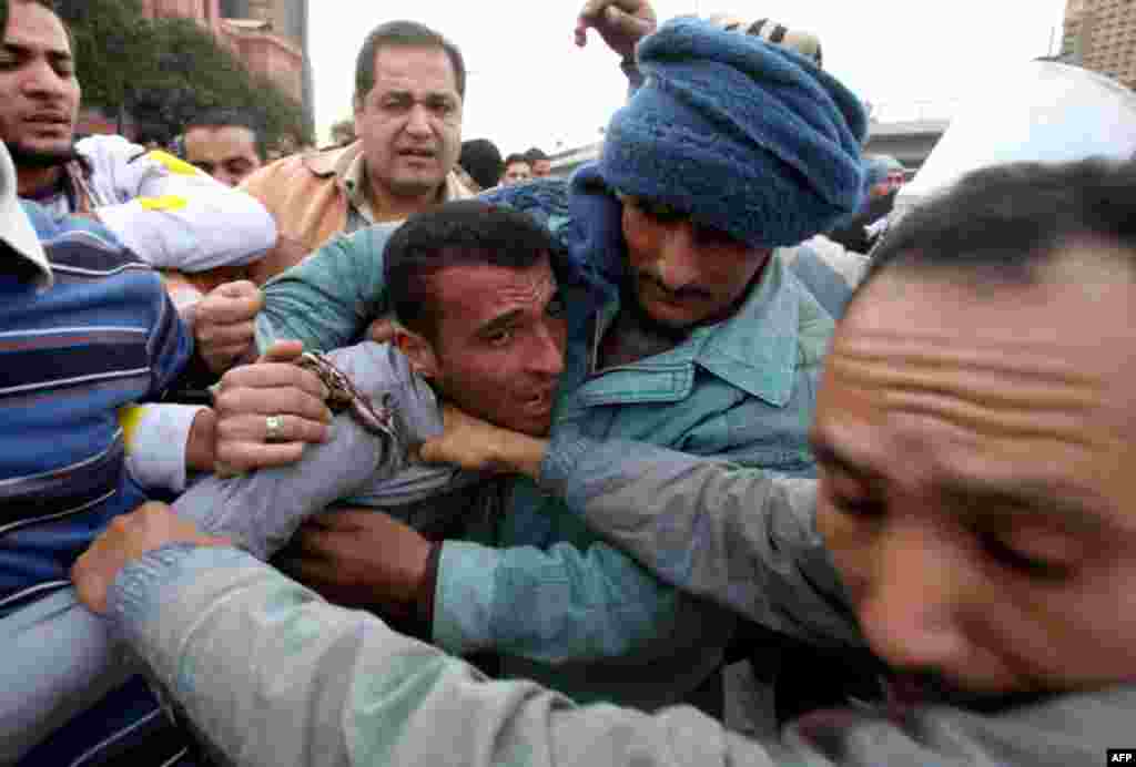 February 3: A pro-Mubarak supporter apprehended by opposition demonstrators is led away during rioting. (Suhaib Salem/Reuters)