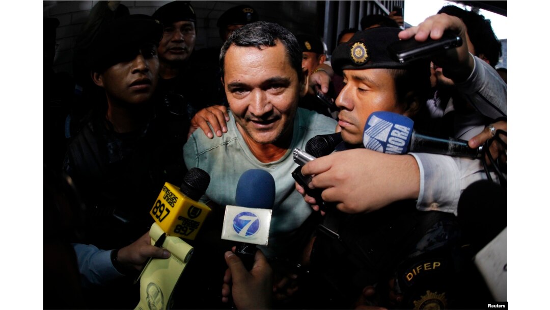 FILE - Waldemar Lorenzana (C) speaks with members of the media after his arrest at the Supreme Court of Justice in Guatemala City, Sept. 17, 2013.