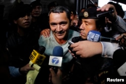 FILE - Waldemar Lorenzana (C) speaks with members of the media after his arrest at the Supreme Court of Justice in Guatemala City, Sept. 17, 2013.