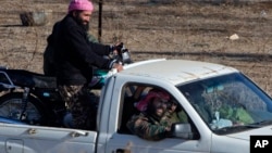 A group of unidentified militants drive near Syria's Quneitra border crossing between Syria and the Israeli-controlled Golan Heights, seen from the Israeli-controlled Golan Heights, Nov. 28, 2016. Israeli aircraft struck a machine gun-mounted vehicle inside Syria Nov. 27, killing four IS-affiliated militants inside after they had opened fire on a military patrol on the Israeli side of the Golan Heights, the Israeli military said.